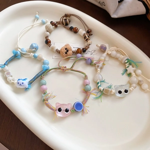 Detailed view of handmade ceramic beaded bracelets with cute cartoon cat and bear charms