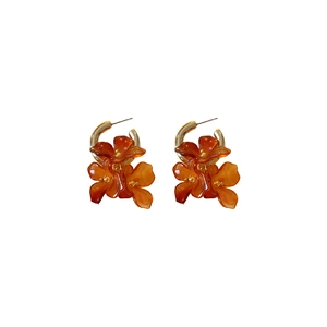 Retro amber resin flower earrings with gold metal hoops on white background