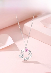 Macro detail of S925 silver necklace with pink heart stone and butterfly charm