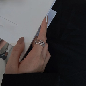 Detail of silver double-layered crisscross ring with zircons on a book background