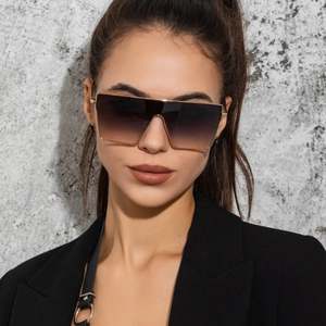 Front view of model wearing oversized gold frame square sunglasses with gradient brown lenses