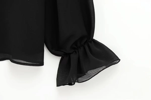 Detailansicht einer schwarzen Chiffonbluse mit gestuften Rüschenmanschetten und Gummibund