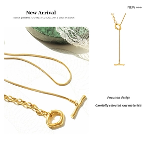 Detailed view of asymmetric gold-plated snake chain necklace with wave toggle clasp
