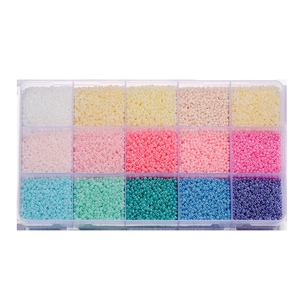 Top-down view of a 15-compartment organizer filled with colorful matte glass seed beads