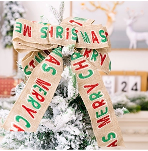 Detailed close-up of a linen Christmas bow with Merry Christmas printing and red accents
