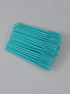 Close-up of disposable spiral mascara wands with bright cyan handles and black fiber bristles