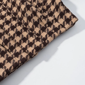 Macro shot of brown and beige houndstooth wool fabric texture for winter sets