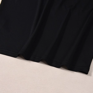 Gros plan détaillé de l'ourlet de la robe en maille noire avec couture à double aiguille