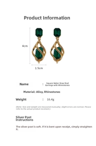 Detail view of geometric drop earrings with green rhinestones and spiral gold design