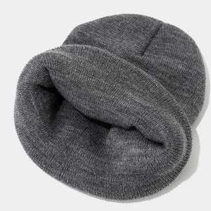 Détail du bonnet en maille gris foncé montrant la matière épaisse et la texture interne