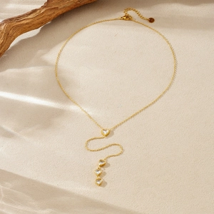Gold plated heart tassel necklace with crystal accents and elegant drop chain design