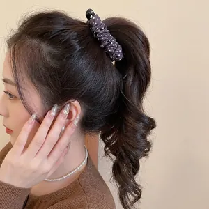 Pince à cheveux à pois violets pour queue de cheval portée sur un modèle