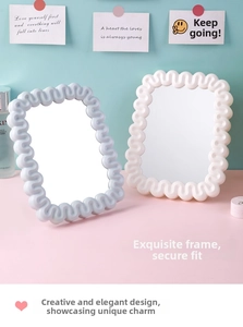 Detail view of wavy cream style makeup mirrors in pastel blue and white colors