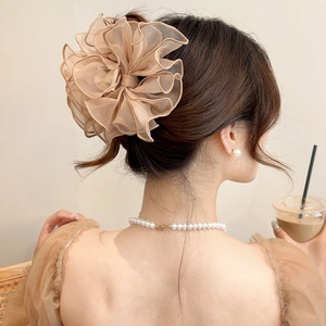 Pince à cheveux fleur en tulle abricot pour chignons de femmes dans un ton beige doux