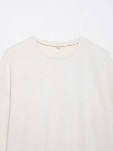 Detail of cream white long sleeve top showing round neck collar and S size label