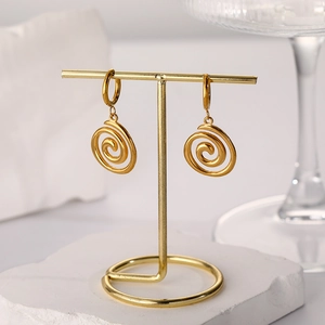 Close-up of 18k gold plated spiral pendant hoop earrings on a professional display