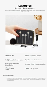 Detail showing black PU leather mini purse with daisy embroidery and plush pendant