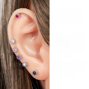 Macro shot of six colorful zircon cartilage studs with beaded edge details on an ear model