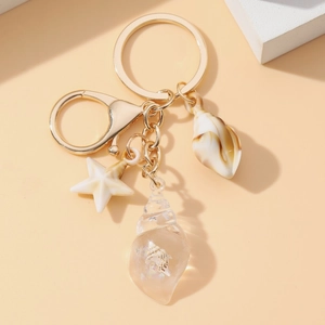 Close-up of golden keychain with luminous starfish, conch and resin shell pendants