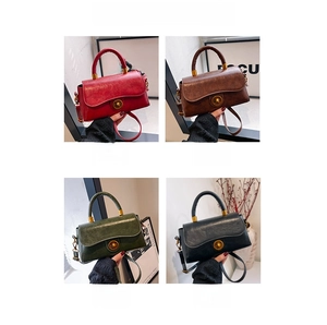 Detailed view of vintage waxed leather handbag with gold twist lock and elegant top handle