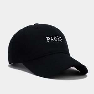 Detail of white PARIS embroidery on a black cotton twill baseball cap with curved brim