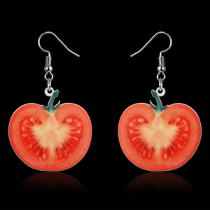 Detail view of red tomato slice earrings with green stem detail on black background