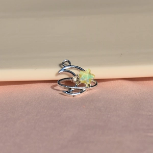 Vue macro d'un pendentif lune et étoile argenté avec incrustation d'opale et zircon