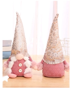 Close-up of pink sequined gnome dolls with white beards on a cozy wooden table decor