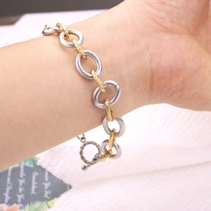 Detail of two-tone gold and silver toggle clasp bracelet with spiral textured link chain