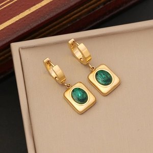 Detailed close-up of emerald square earrings on a jewelry box with a gold-plated finish