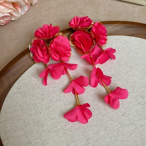 Macro view of long chiffon tassel earrings with vibrant rose pink fabric flowers