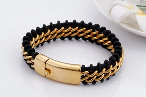 Detail of black braided leather strap with brushed gold metal clasp on men's bracelet