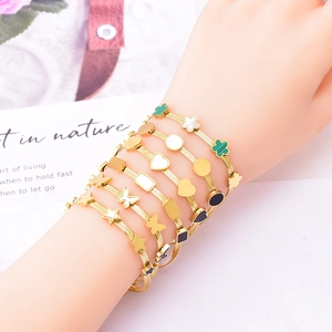 Bracelets dorés avec pendentifs trèfle, cœur et papillon en nacre pour un look élégant