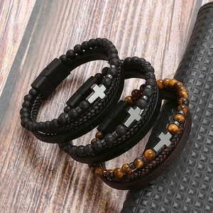 Mens bracelet set with natural volcanic stone tiger eye and metal cross on wood background