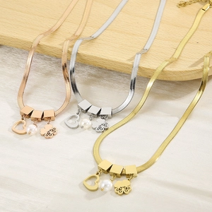 Elegant gold and silver snake chain necklaces with pearl and heart pendants on silk