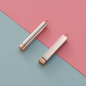 Detailed view of silver and rose gold cylindrical and rectangular metal urn pendants