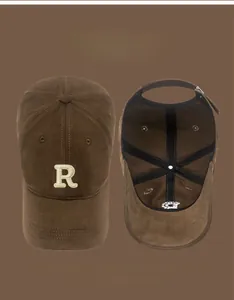 Detail of coffee baseball cap featuring white embroidered R letter and inner lining