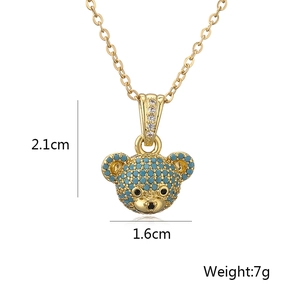 Detail shot showing a 2.1cm x 1.6cm 18K gold teddy bear pendant with blue stones
