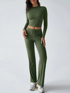 Women's green two-piece yoga set featuring a long sleeve crop top and flared drawstring pants