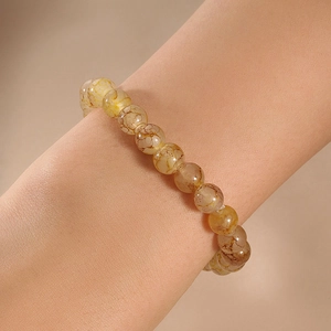 Detail of amber beaded bracelet with natural brown veins on a model wrist
