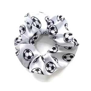 Detail of white satin soccer print hair scrunchie with soft elastic texture