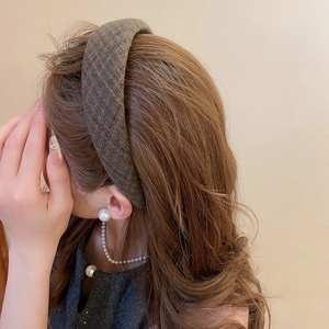 Primo piano del cerchietto spesso a quadri marrone scuro con trama in twill a vista