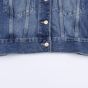 Deep blue denim jacket detail featuring heavy stitching and premium metal buttons