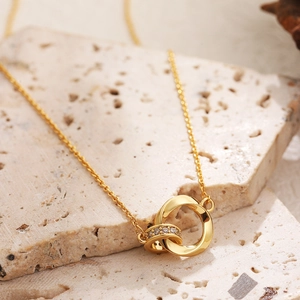 Detail of 18K gold double-ring Mobius necklace with sparkling cubic zirconia on stone