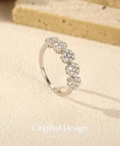 Macro shot of silver flower cluster ring with sparkling stones on textured stone base