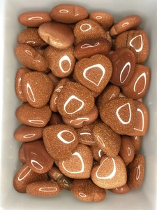 Macro view of polished heart-shaped goldstone crystals with sparkling texture