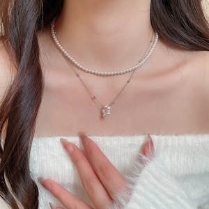Detailed close-up of French vintage double layer pearl necklace on model neck