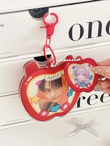 Macro detail of red apple acrylic photo card holder with matte metal hook and beads