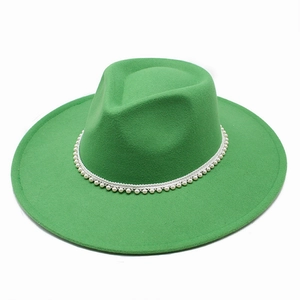 Detail view of emerald green wool fedora hat featuring white pearl decorative band
