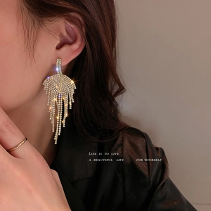Sparkling silver leaf tassel earrings with rhinestones on a model for luxury fashion styling